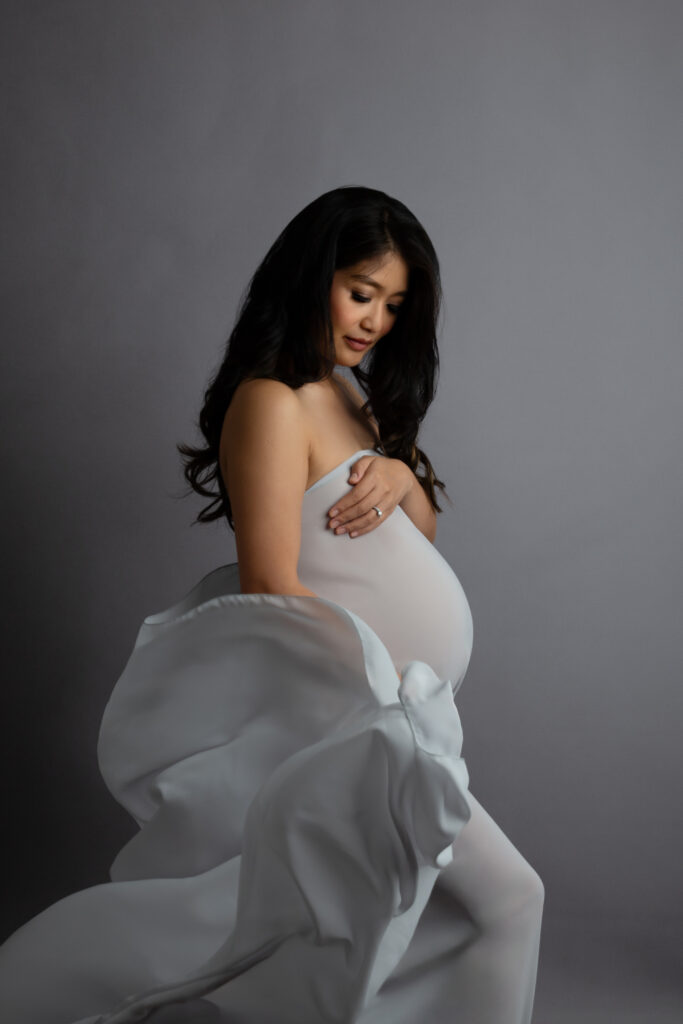 Maternity photoshoot with grey fabric.